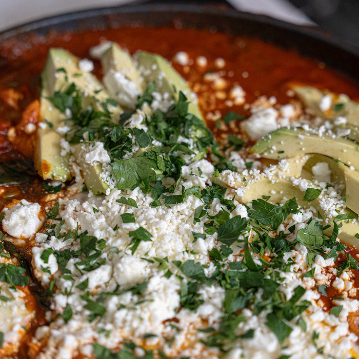 Close up photo of shakshuka in a Swiss Diamond Fry pan with avocado and feta on top