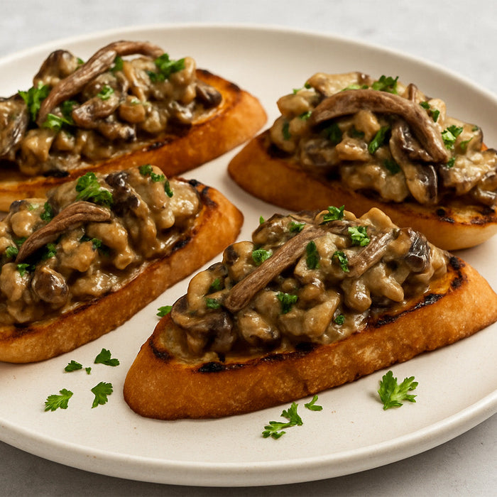 Spicy and Creamy Wild Mushrooms with Anchovy Bruschetta on a white plate